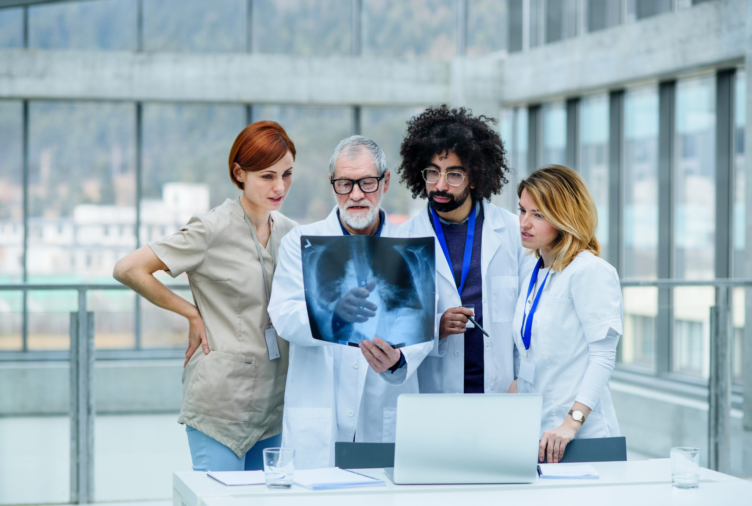 A group of doctors looking at X-ray on medical conference, discussing issues.